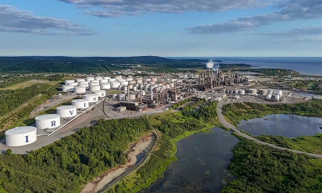 Aerial view of the Irving Oil Refinery in Saint John, New Brunswick, with many storage tanks and industrial structures.