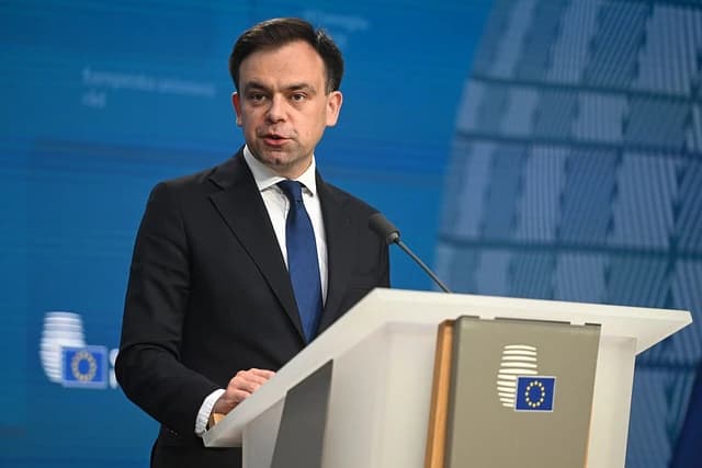 Andrzej Domański, Poland's Minister of Finance, speaks at a podium.