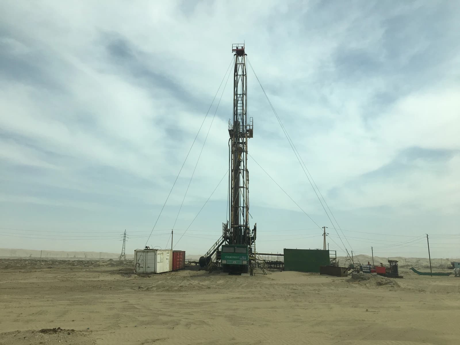 Oil drilling rig on the Cheleken Peninsula under a light blue cloudy sky.