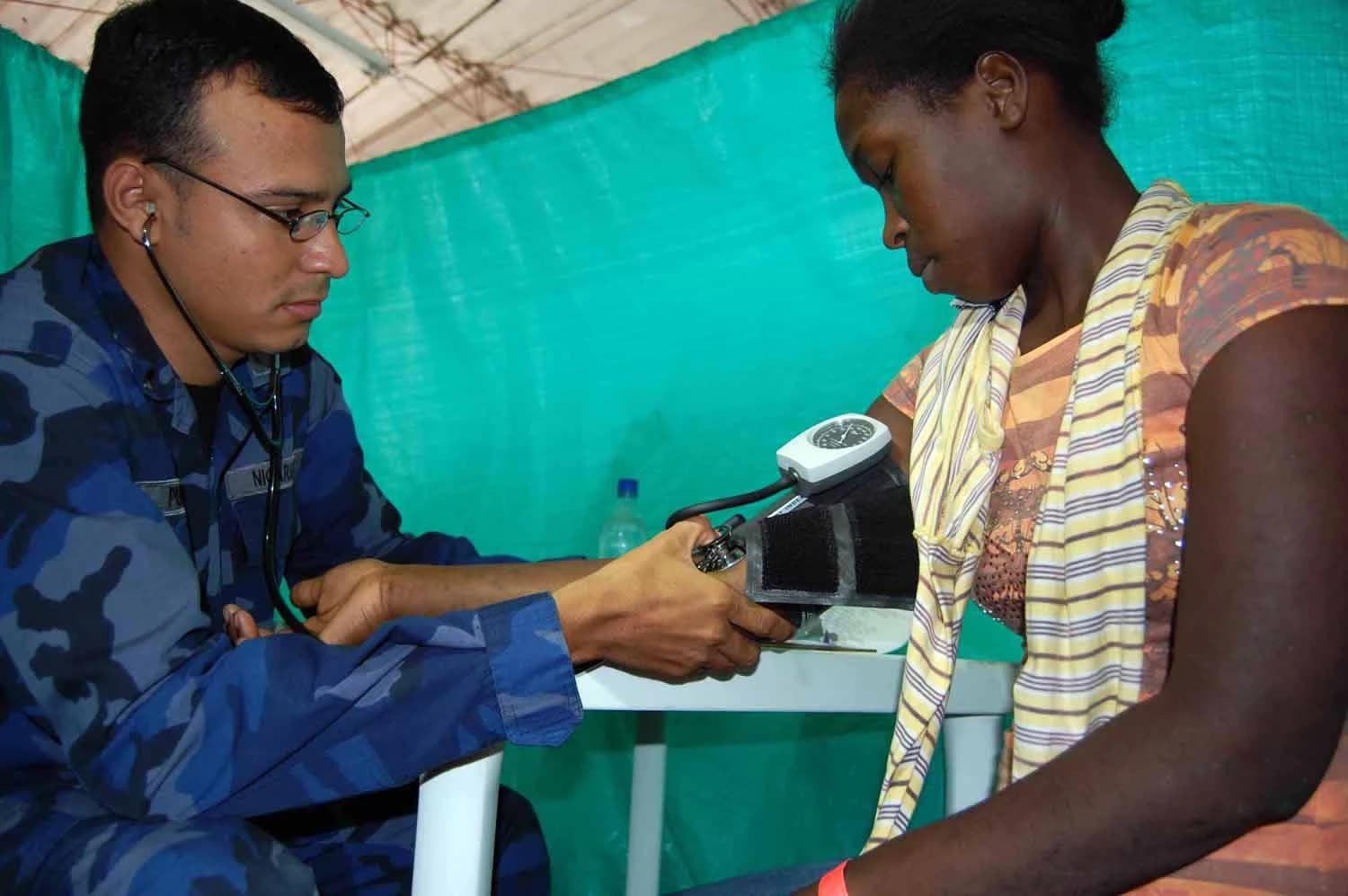 Lt. Carlos Perez checks a patient's blood pressure with a cuff and stethoscope.