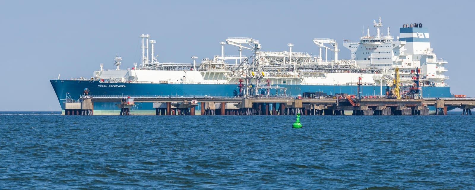 FSRU Höegh Esperanza, a floating storage and regasification unit, docked at a pier.