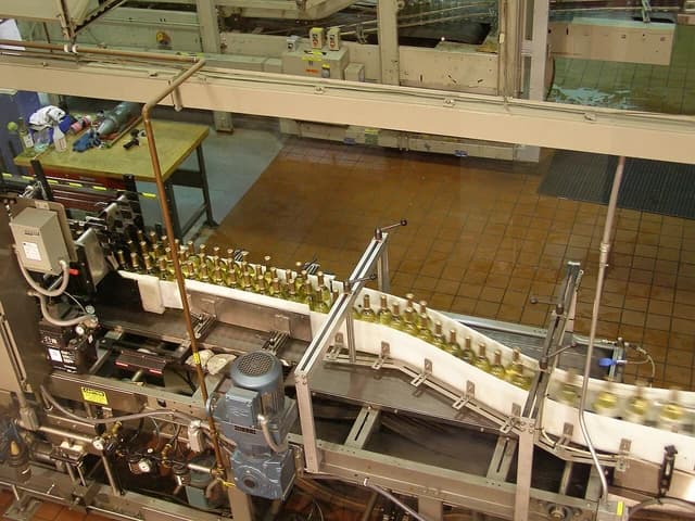 Wine bottles on a white conveyor belt in a bottling plant at Chateau Ste. Michelle Winery.