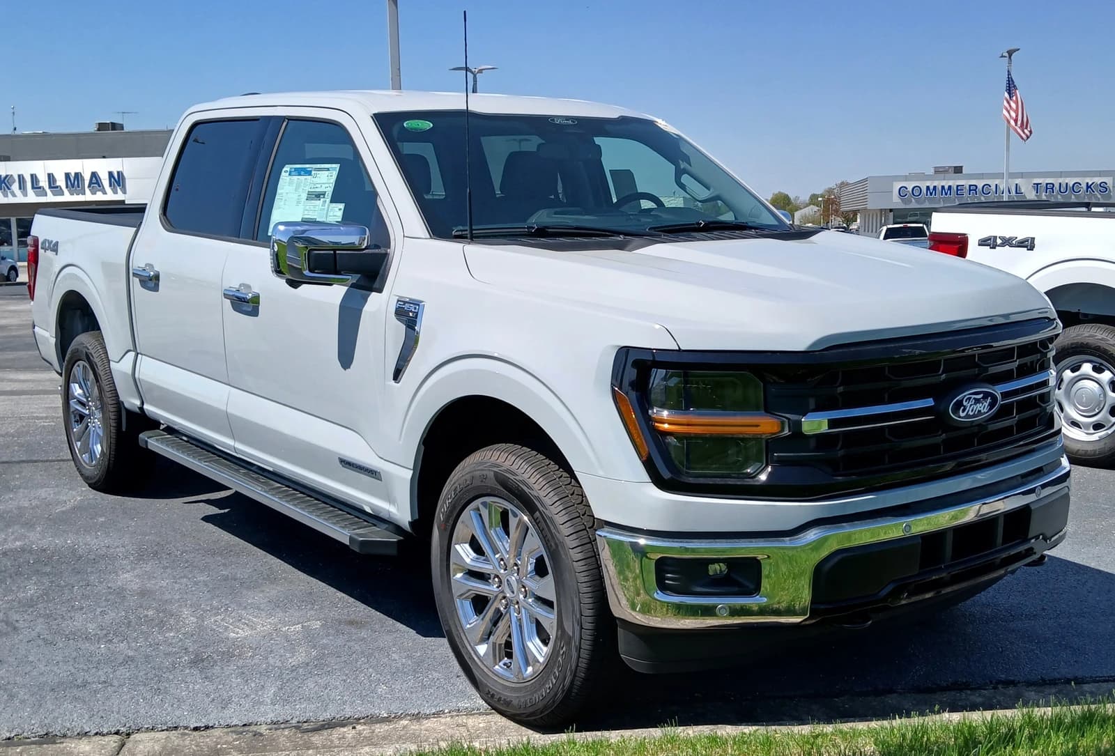 White 2024 Ford F-150 XLT SUPERCREW pickup truck at a car dealership.