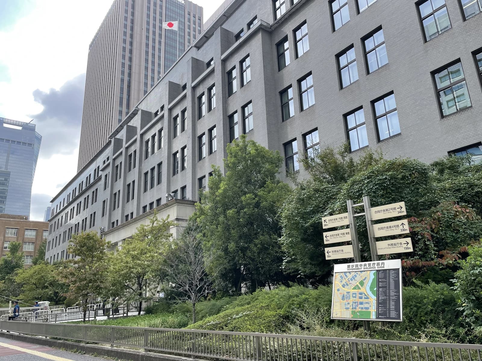 Exterior of the Ministry of Finance building in Tokyo, Japan, with a Japanese flag visible.