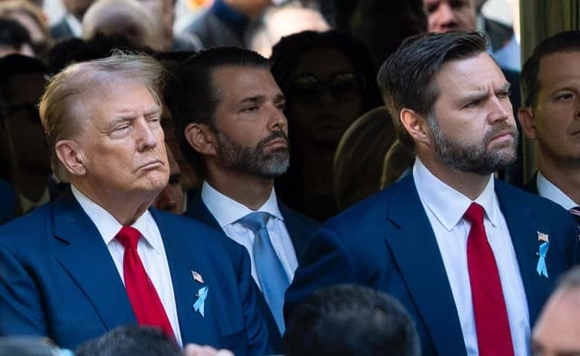 Donald Trump and JD Vance standing side-by-side at a public event, looking forward.
