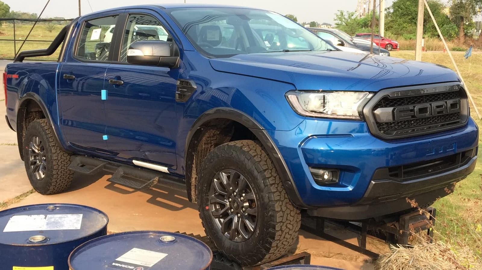 Blue Ford Ranger FX4 MAX Double-Cab pickup truck on display, side view.