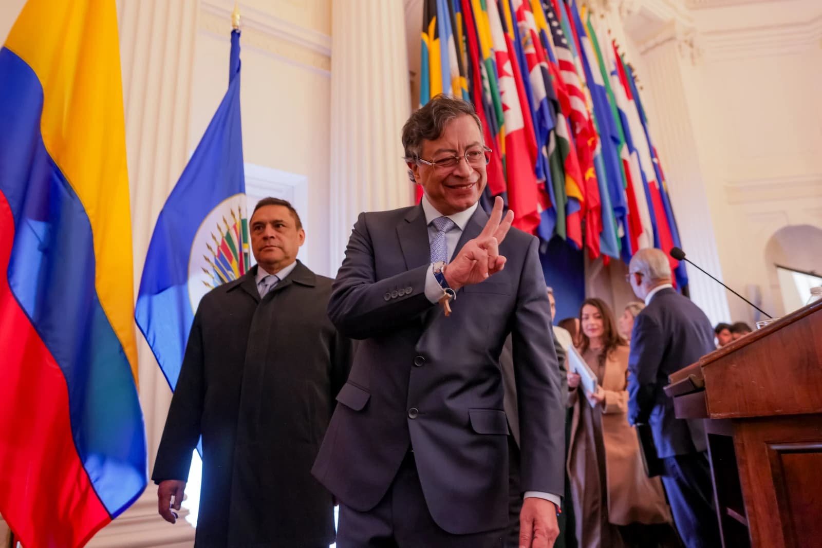 Gustavo Petro, President of Colombia, speaking at a podium with flags in the background.