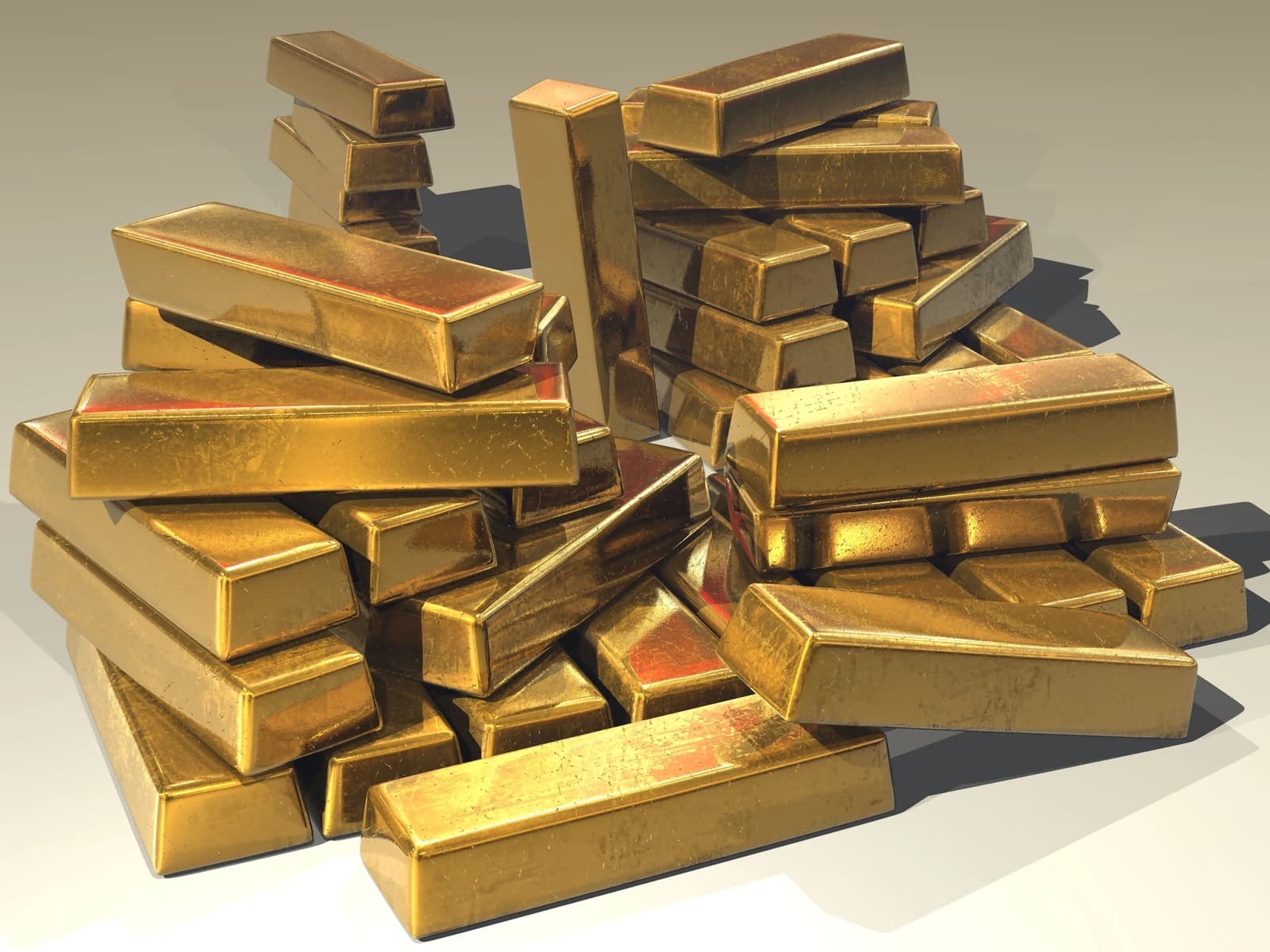 Numerous shiny rectangular gold bars stacked and scattered together.