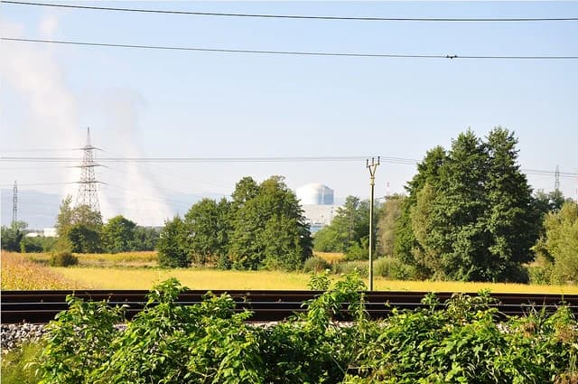 Krško Nuclear Power Plant, Slovenia, with a containment dome visible behind trees and power lines.