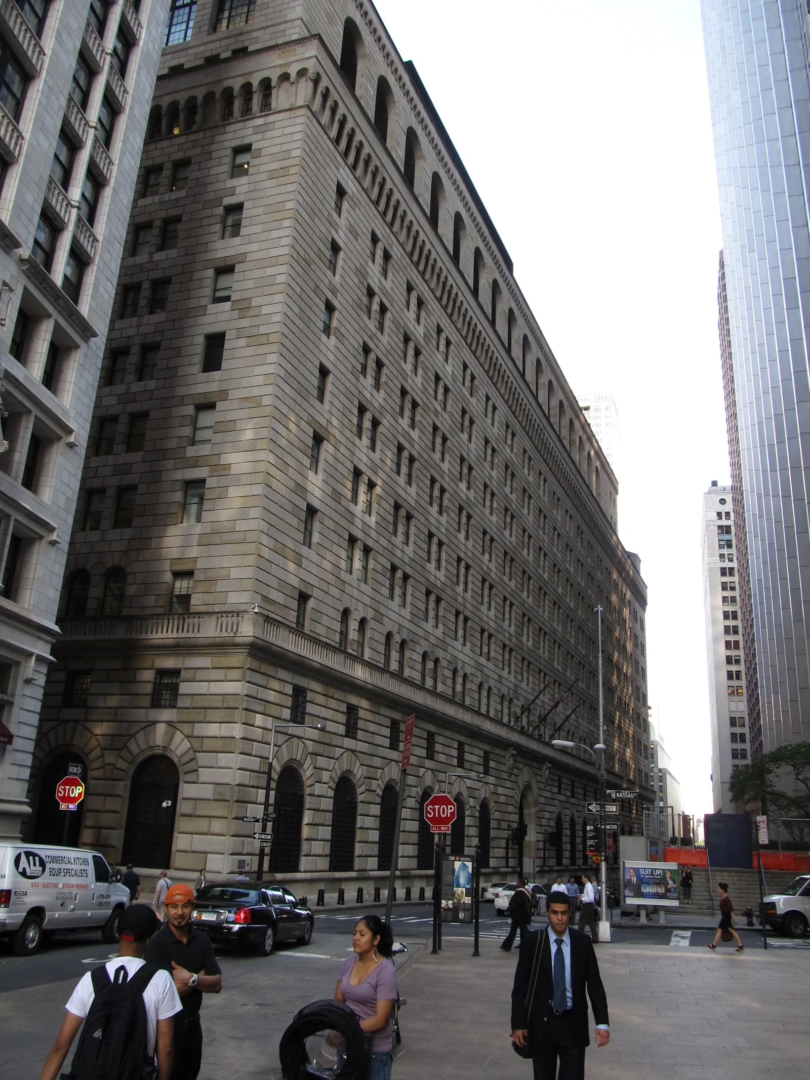 Federal Reserve Bank of New York building with pedestrians on the street below.