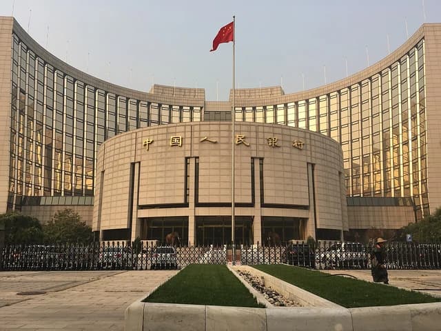 The People's Bank of China headquarters building in Beijing under a clear sky.