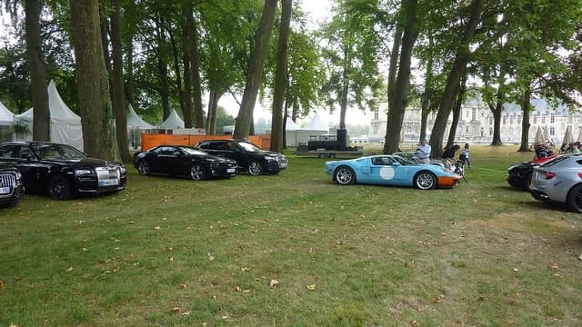 Blue and orange Ford GT parked on grass at an outdoor car event.