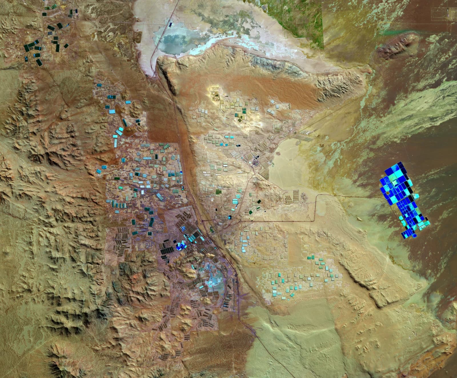 Aerial view of colorful lithium mining evaporation ponds in the vast Atacama Desert landscape.