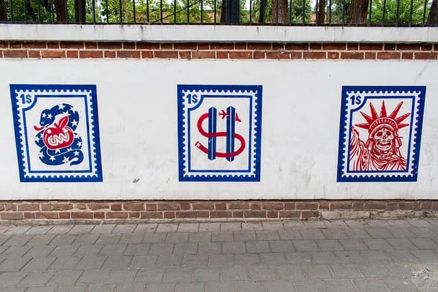 Anti-American murals depicting symbols like the CNN logo and Statue of Liberty with a skull face.