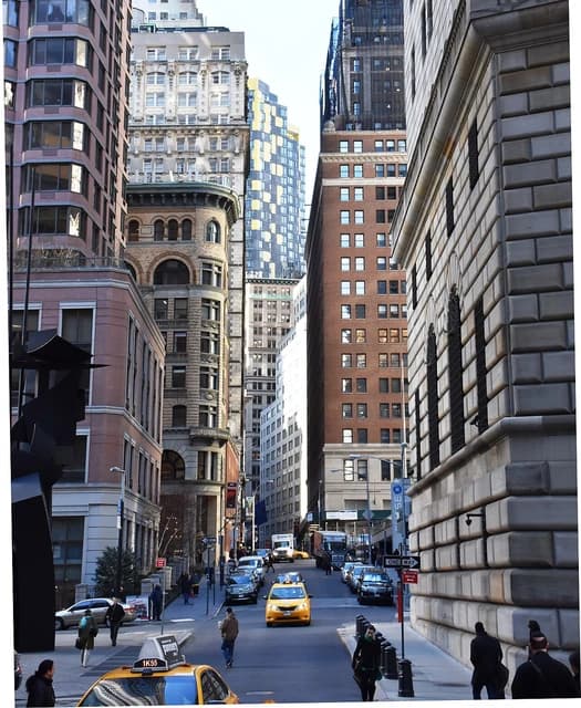Looking down William Street in New York City's Financial District with skyscrapers.