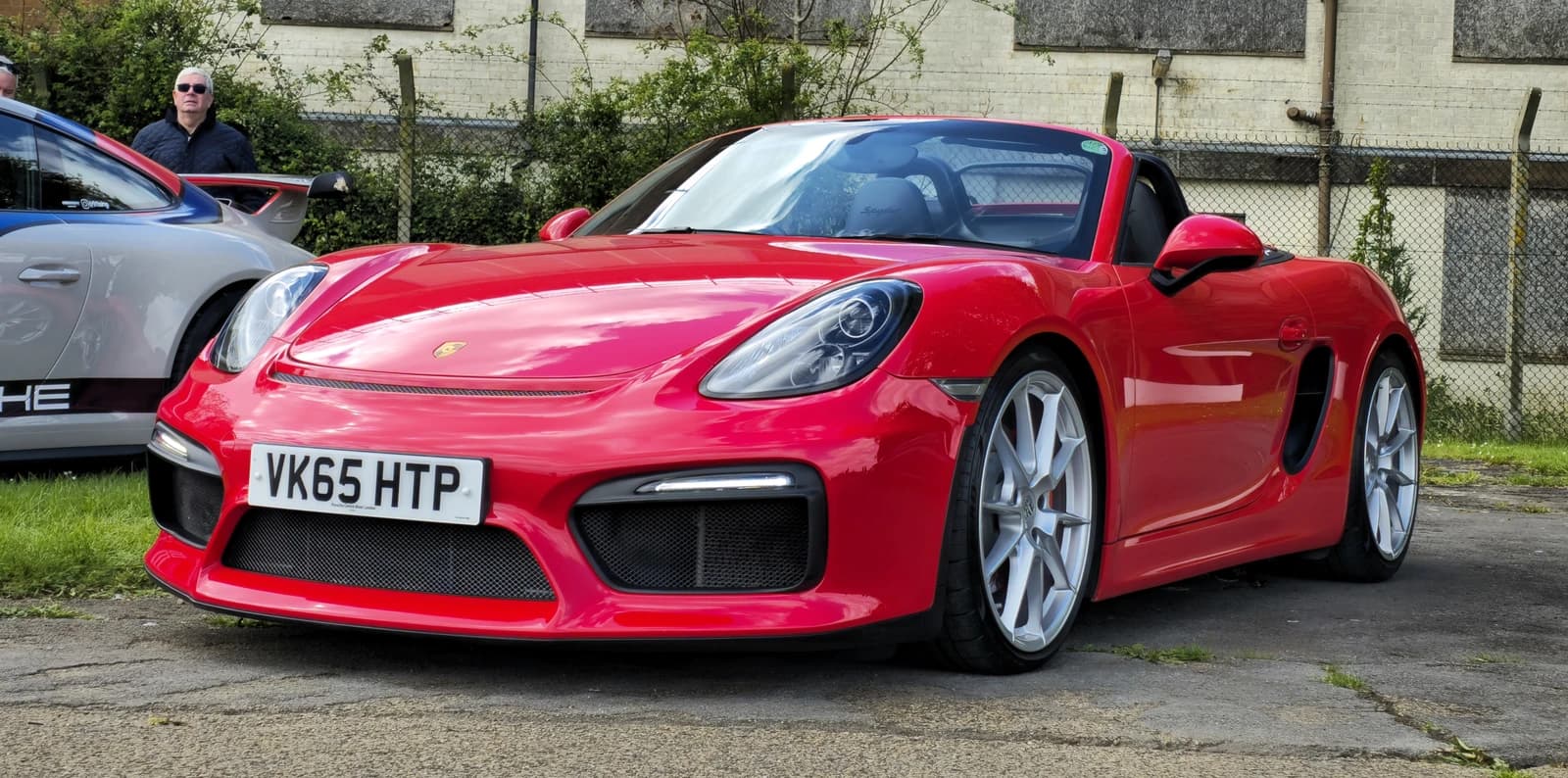 Red 2015 Porsche Boxster Spyder sports car parked on asphalt.
