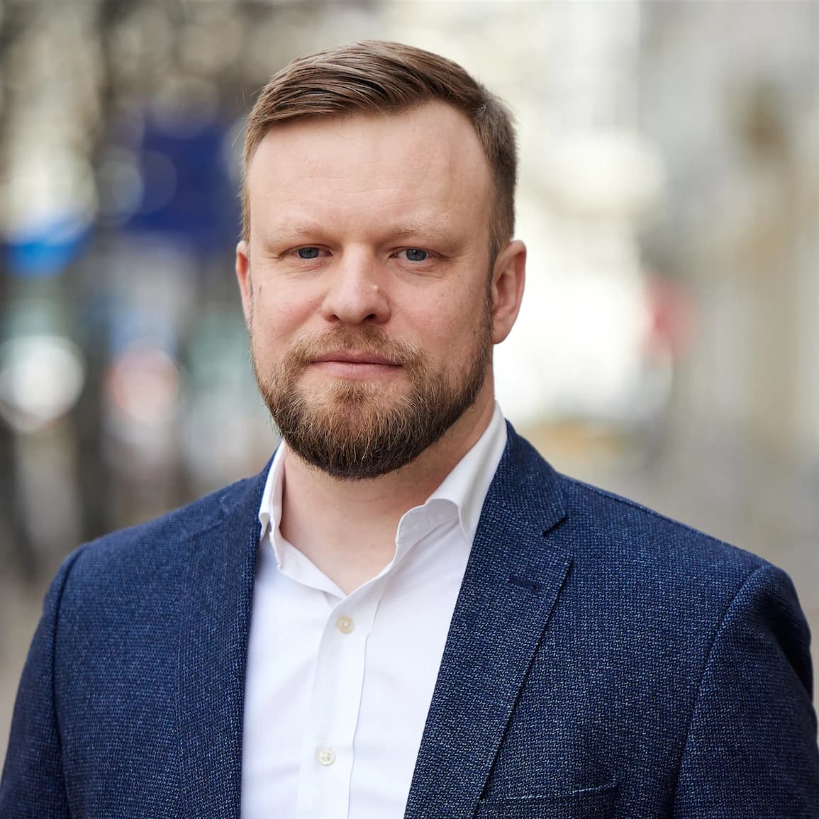 Arsen Makarchuk, a man in a blue suit jacket and white shirt, posing for a headshot.