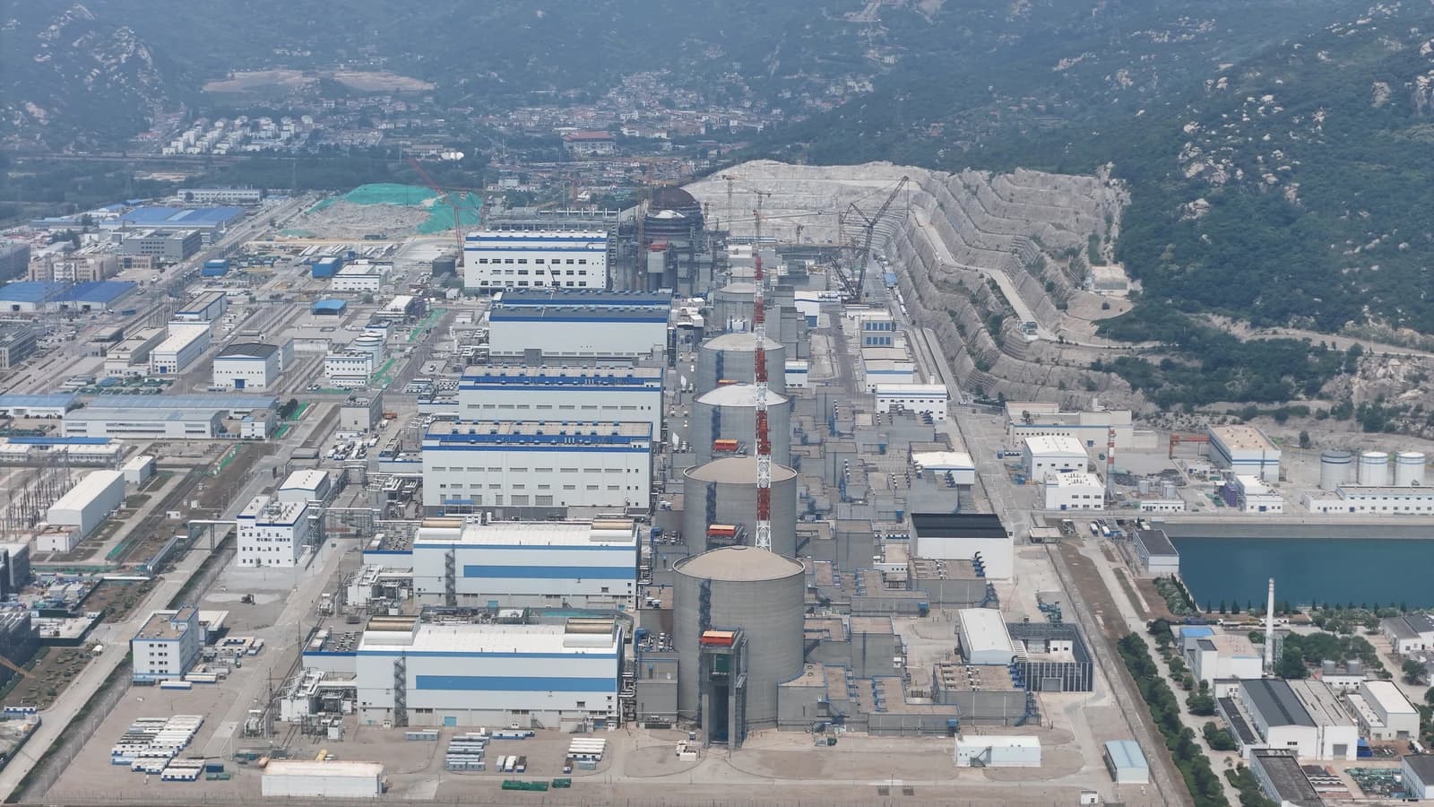 Aerial view of Tianwan Nuclear Power Plant with multiple reactor buildings and surrounding facilities.