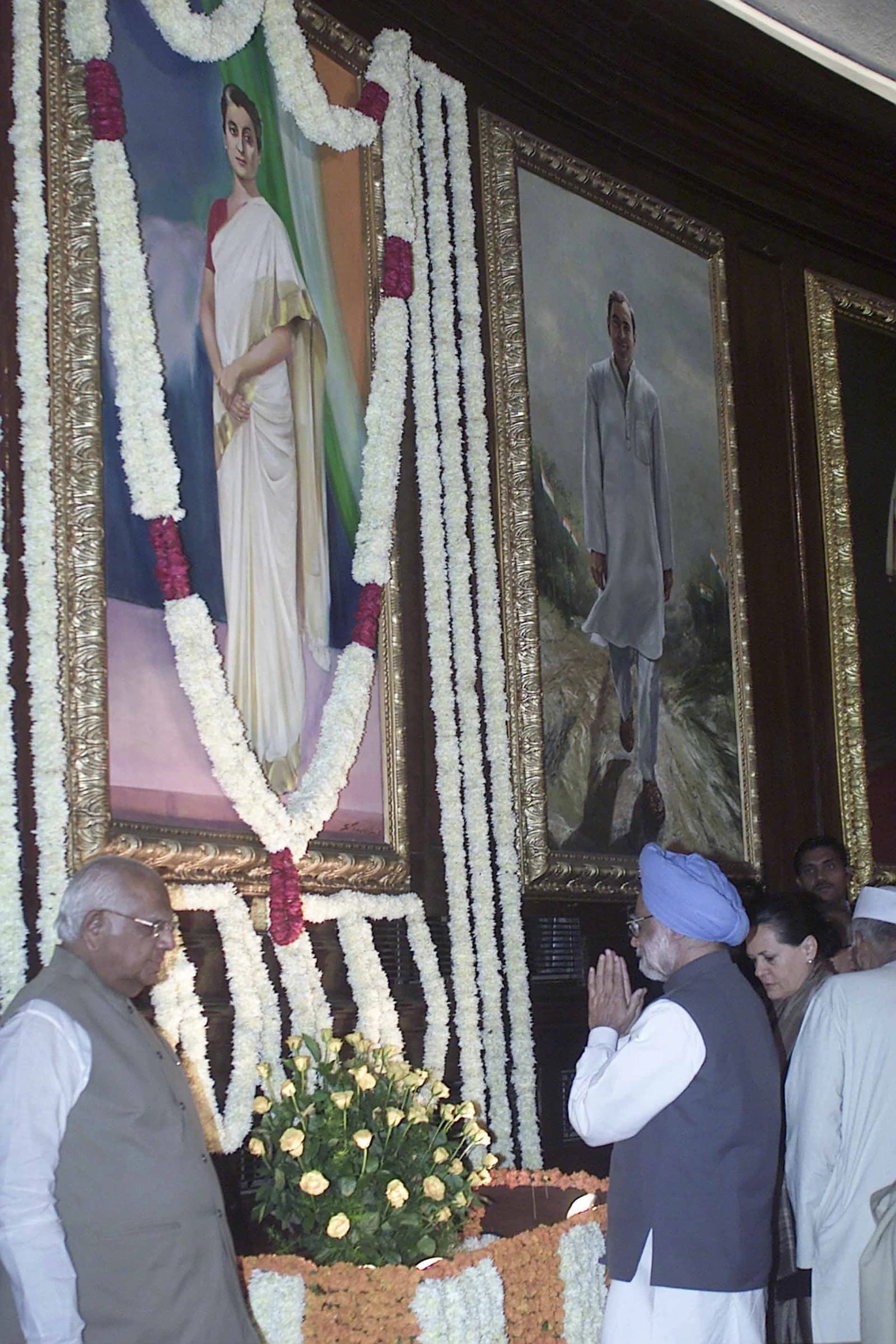 Manmohan Singh standing with folded hands before a portrait of Indira Gandhi in Parliament House.