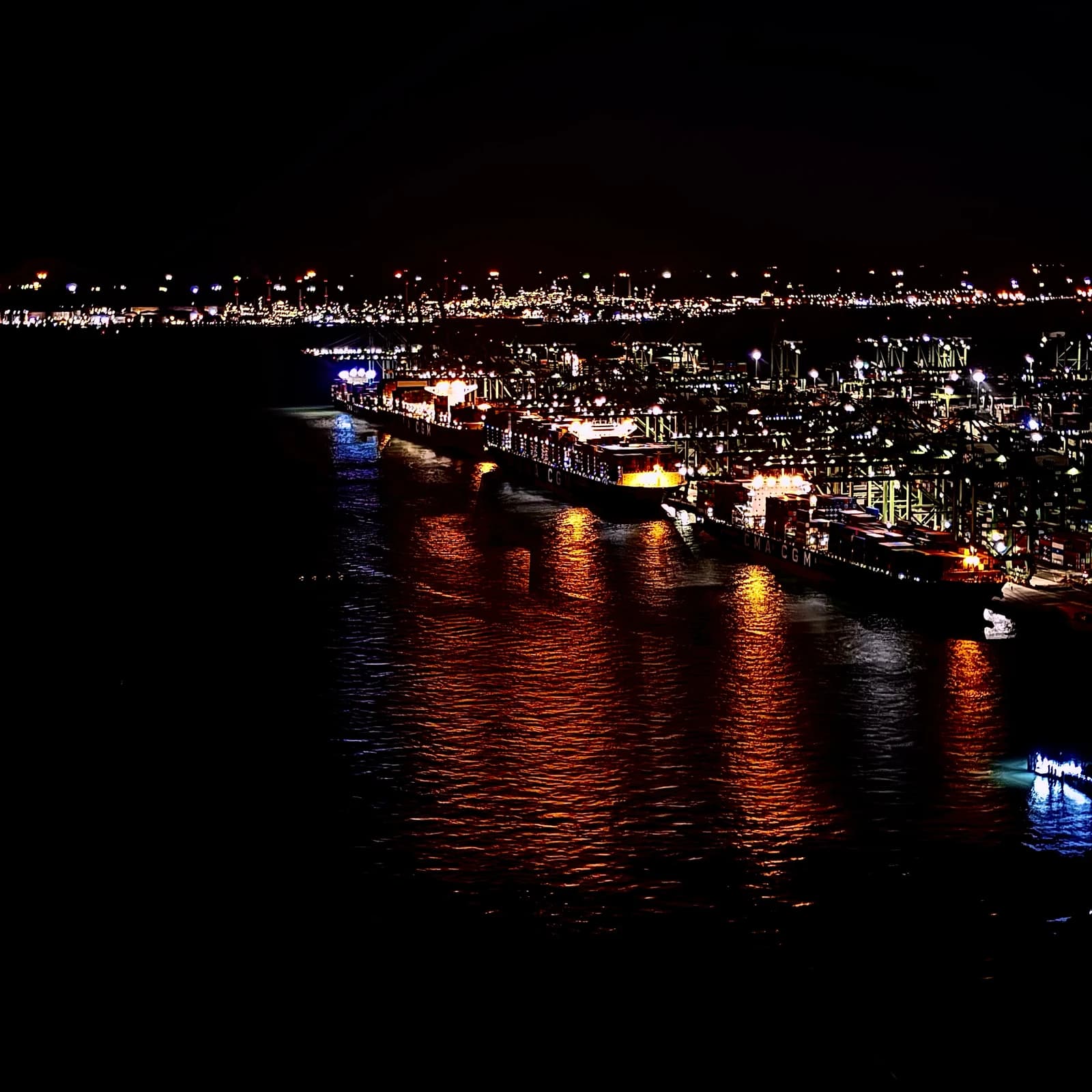 Container ships docked at Pasir Panjang Container Terminal in Singapore at night.