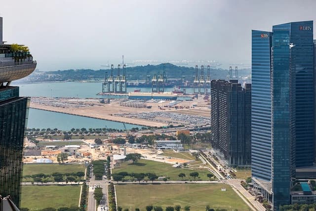Aerial view of Singapore's Tanjong Pagar Terminal with container ships and port cranes.
