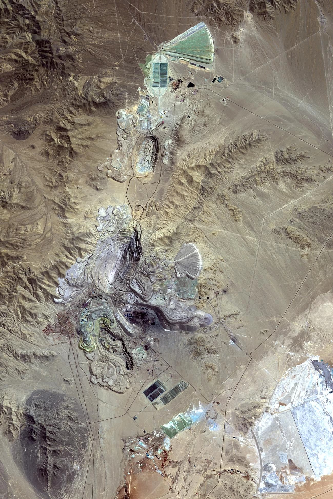 Aerial satellite image of the Chuquicamata Mine in Chile, showing open-pit operations.