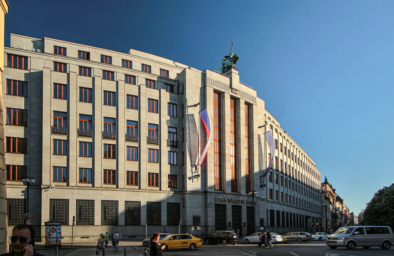 Exterior view of the Czech National Bank building in Prague, under a clear blue sky.