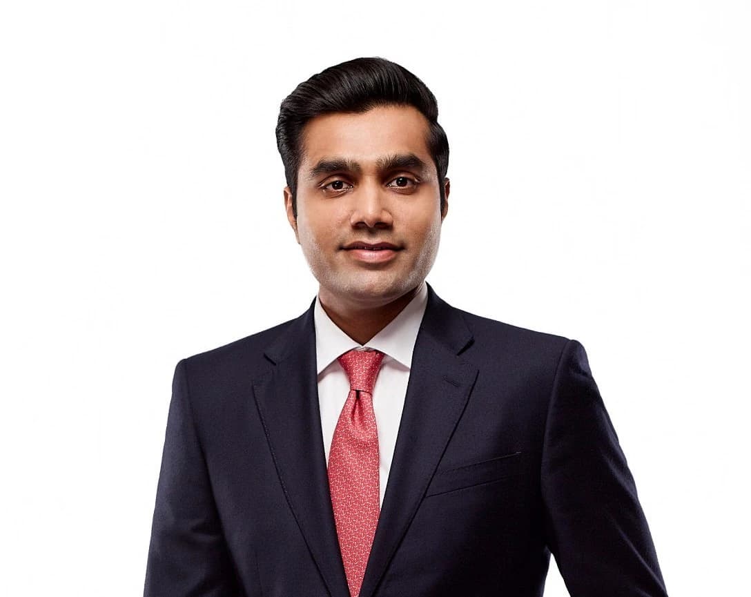 Karan Adani, CEO of Adani Ports, in a dark suit and red tie.