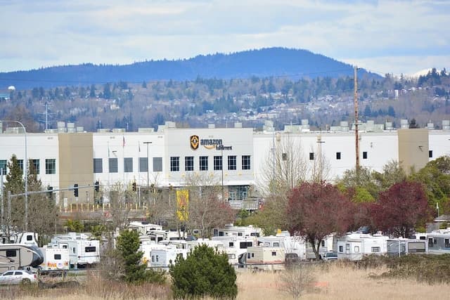 An Amazon Fulfillment Center building with an Amazon logo and text in Kent, Washington.