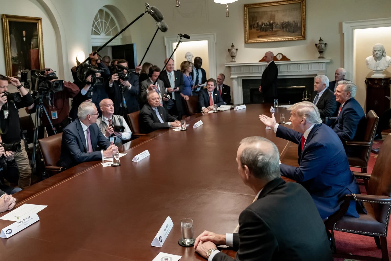 Donald Trump, then President, speaks to energy sector executives at a long table.