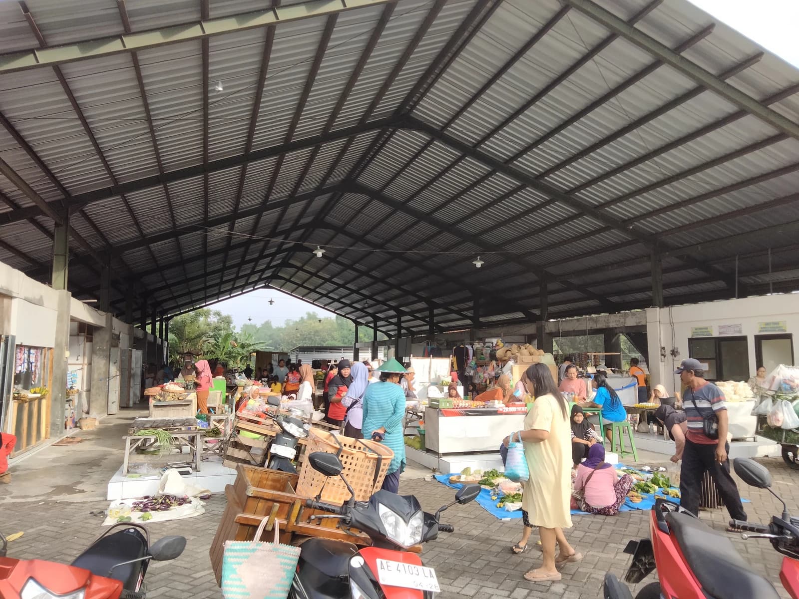 People shop and sell goods at a covered market in Watualang village, Indonesia.