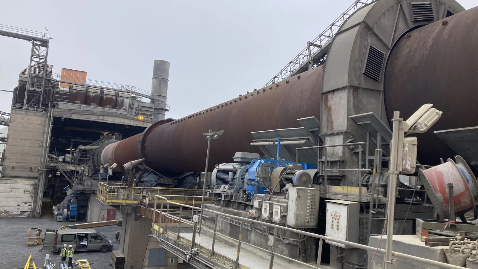 A large industrial cement kiln, a long, cylindrical structure, at a plant in Antoing.