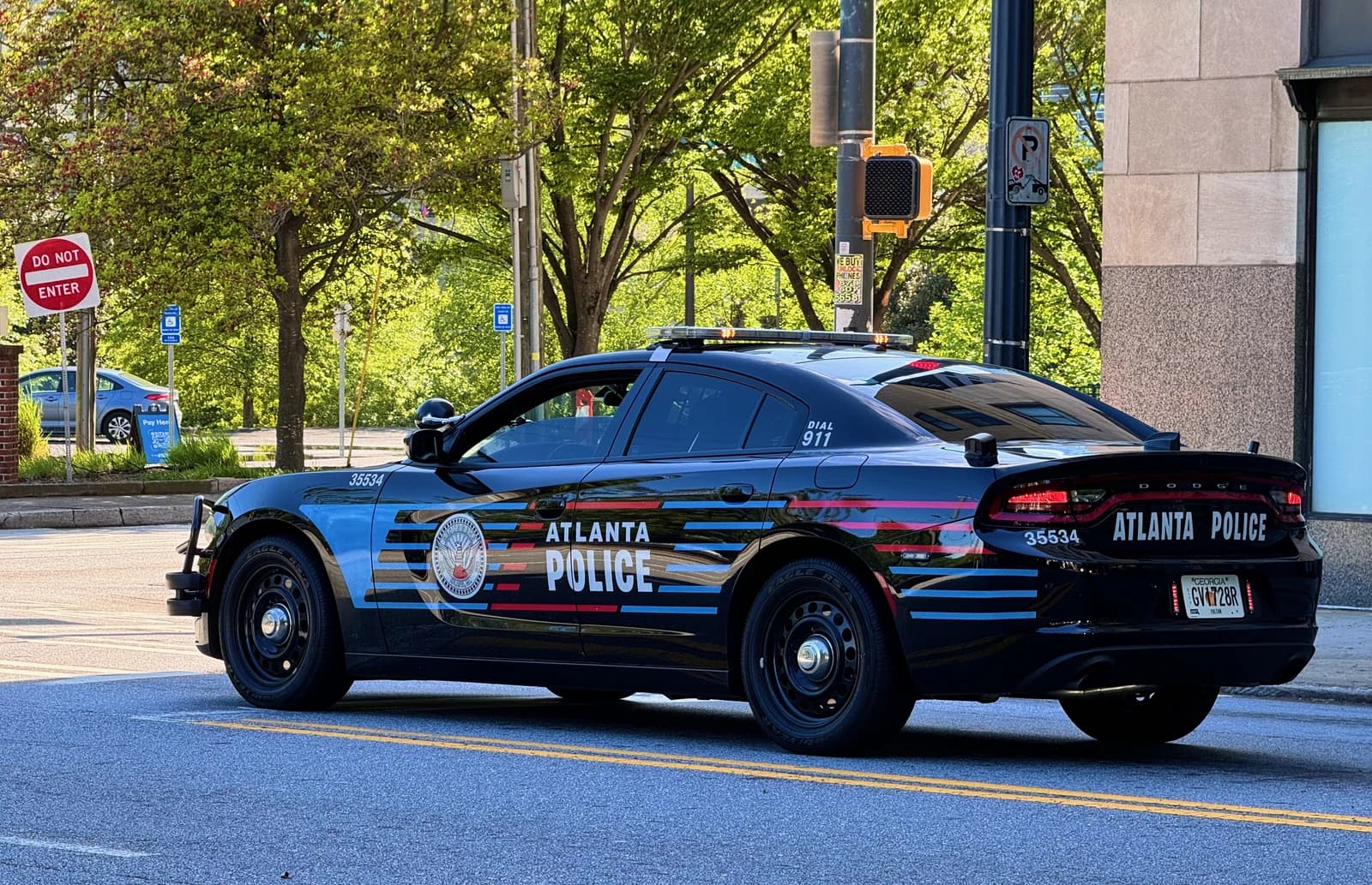 An Atlanta Police Department Dodge Charger Pursuit vehicle is parked on a city street.