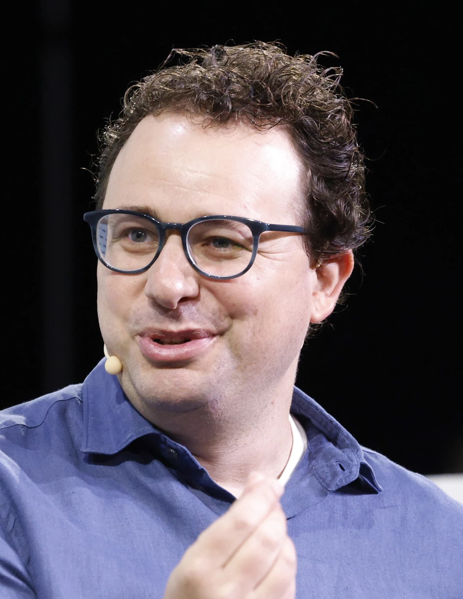 Dario Amodei, CEO of Anthropic, speaking into a microphone at an event.