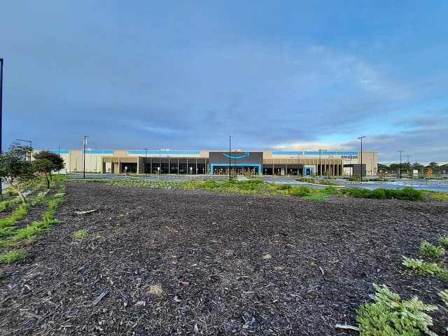 Amazon distribution center building in Jandakot, Australia, with a wide foreground.