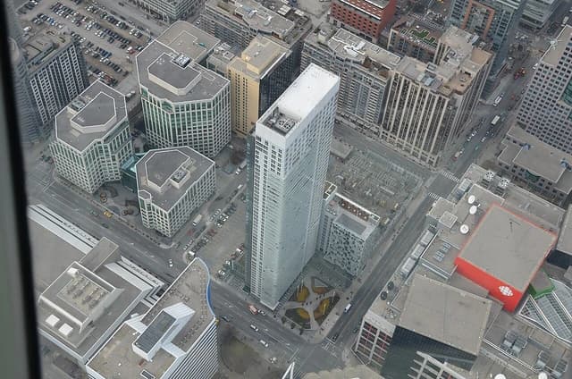 Aerial view looking down at urban landscape with skyscrapers and surrounding streets.