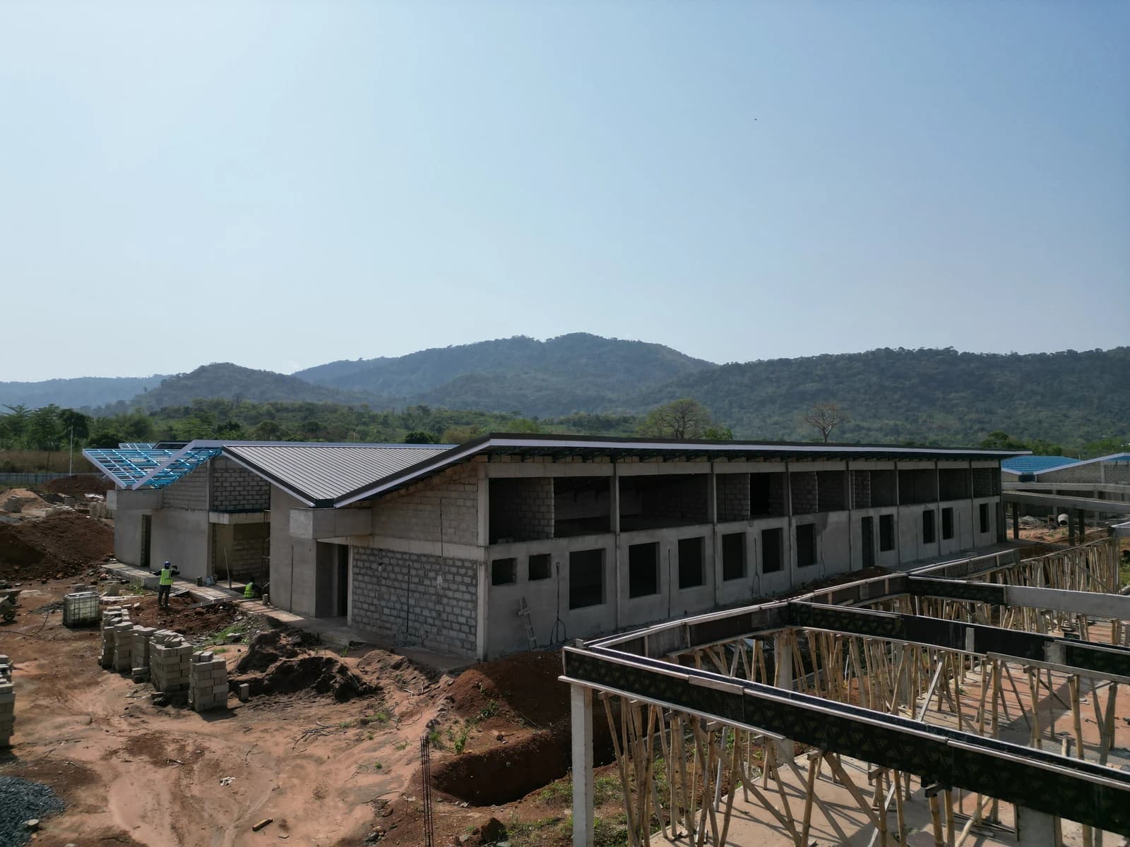 Construction site of a hospital project with partially built buildings and scaffolding.