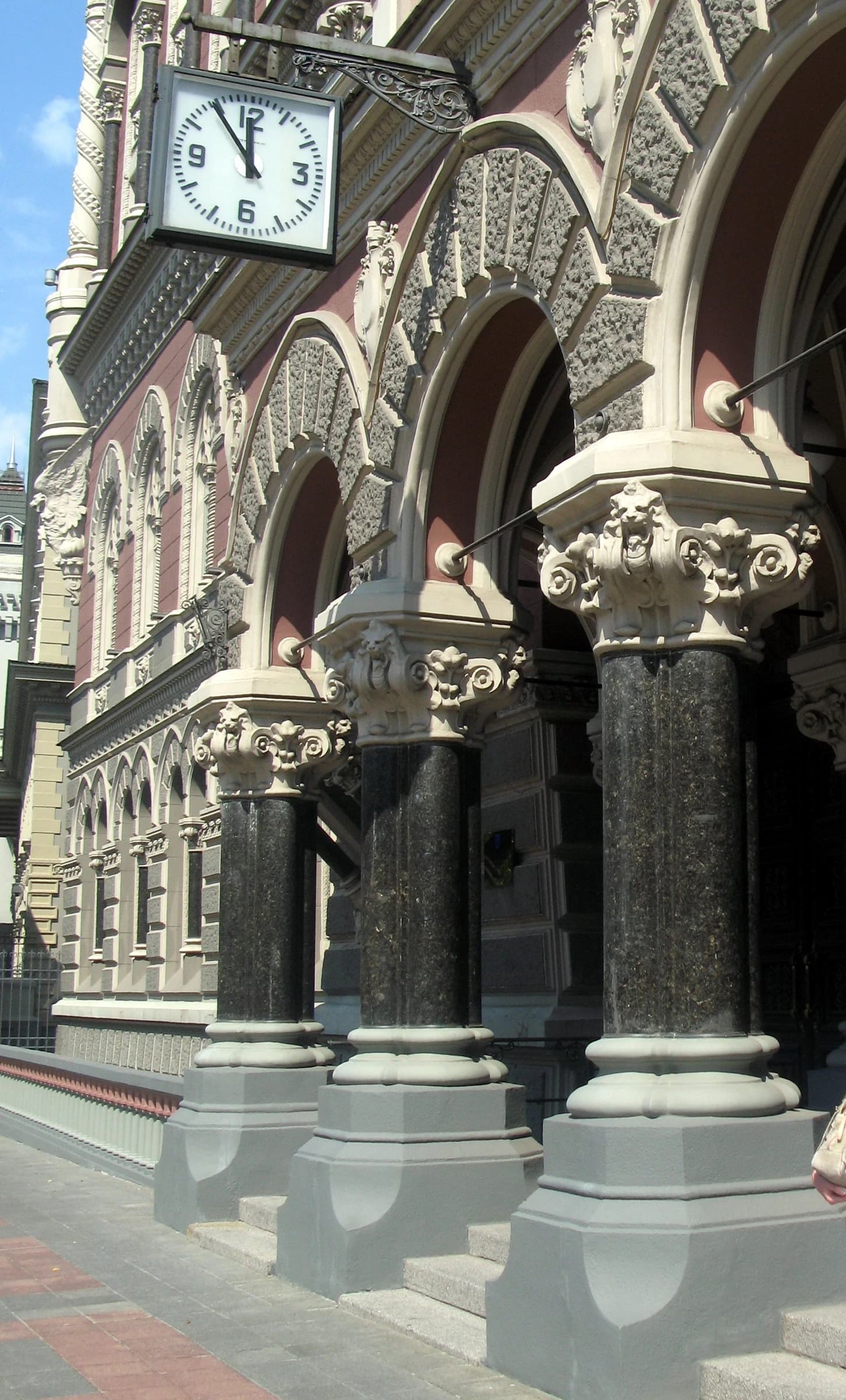 Exterior of the National Bank of Ukraine building with ornate columns and a clock.