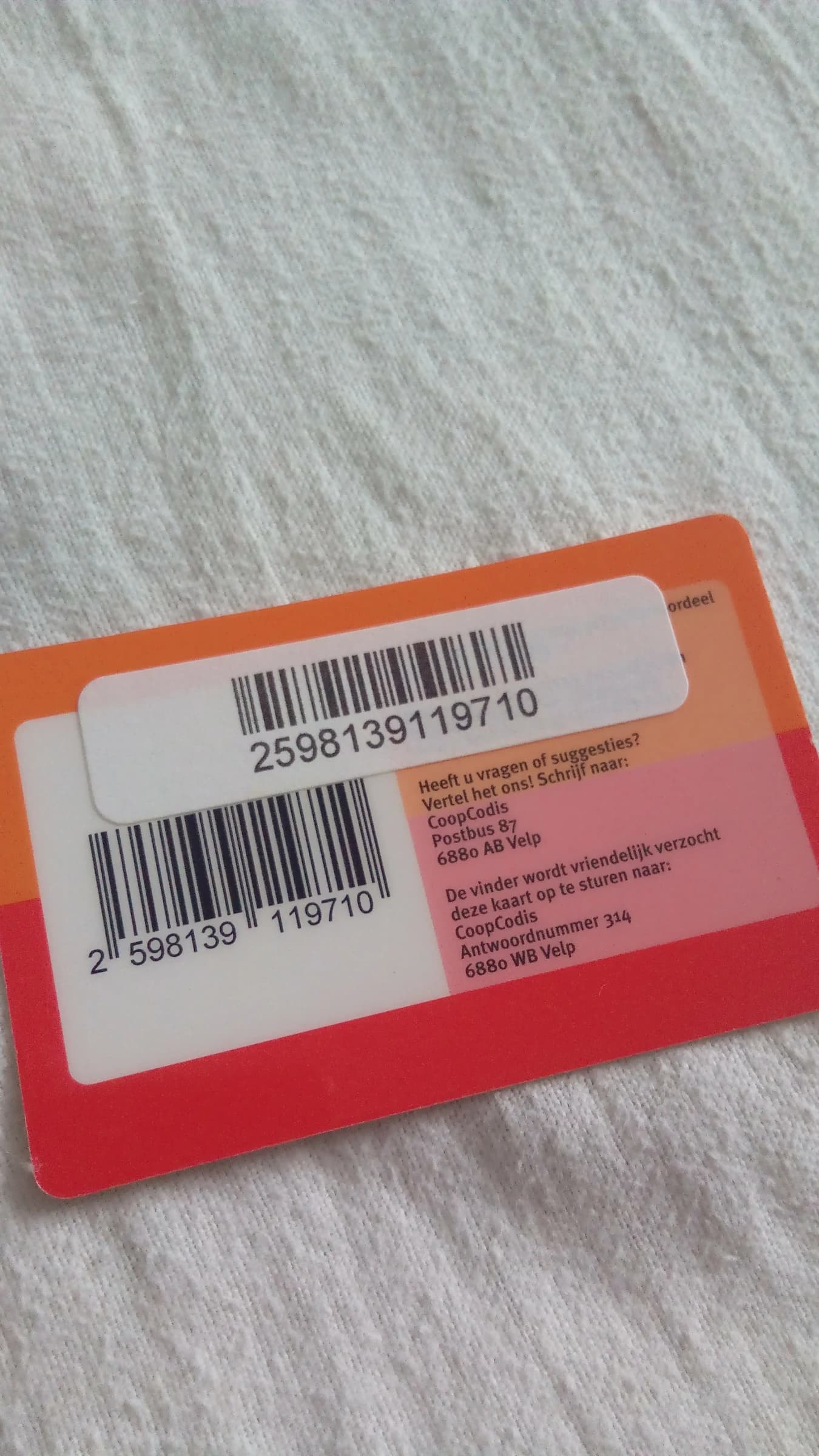 A close-up view of a Coop Club loyalty card, showing a barcode and Dutch text for customer service.
