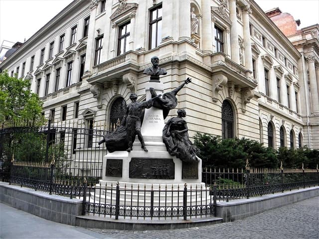 A statue of Eugen Carada, founder of the National Bank of Romania, in front of the bank building.