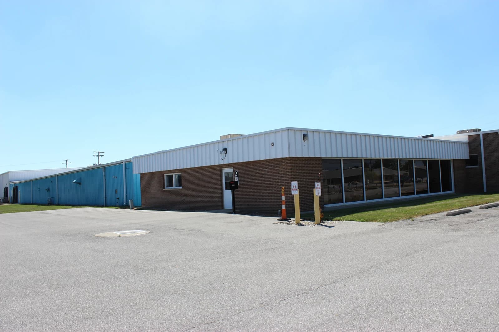 Exterior of a manufacturing plant building with an attached office section.