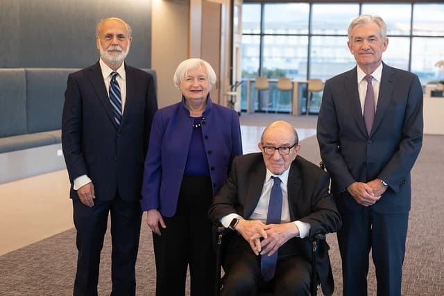 Four chairmen of the US Federal Reserve standing and sitting for a photograph.