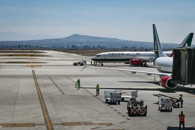 Mexicana de Aviación airplanes on the tarmac with ground crew working around them.