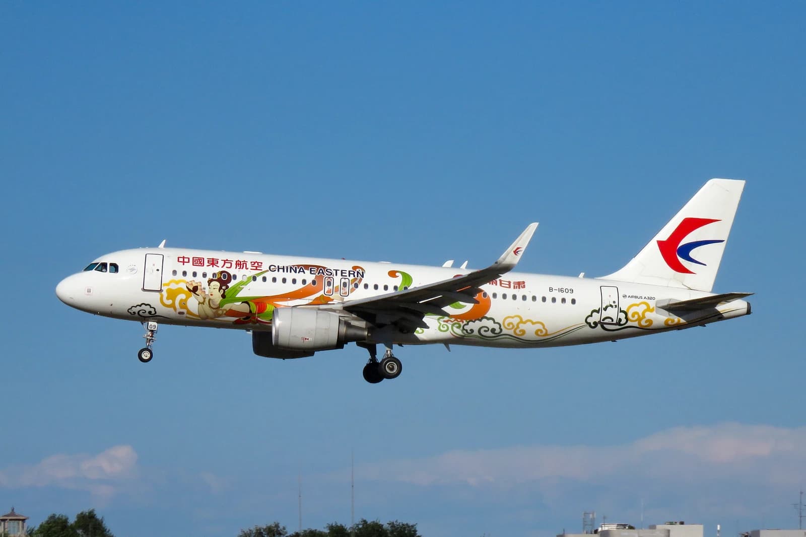 China Eastern Airlines Airbus A320 passenger jet in flight with landing gear extended.