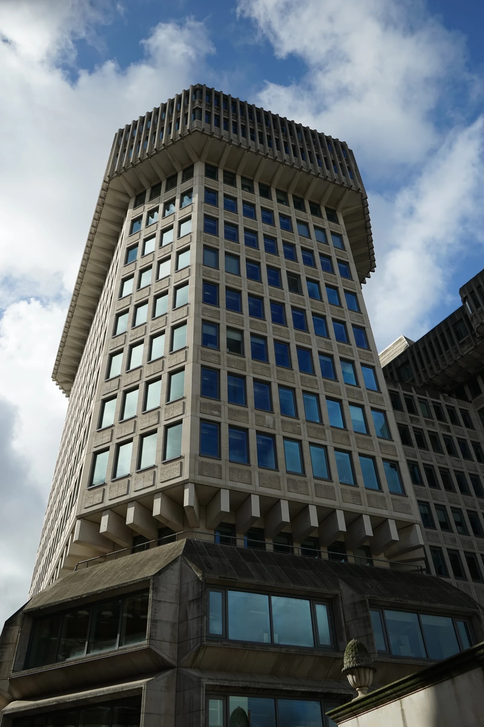 Home Office building exterior viewed from below, showing many windows and a detailed top.
