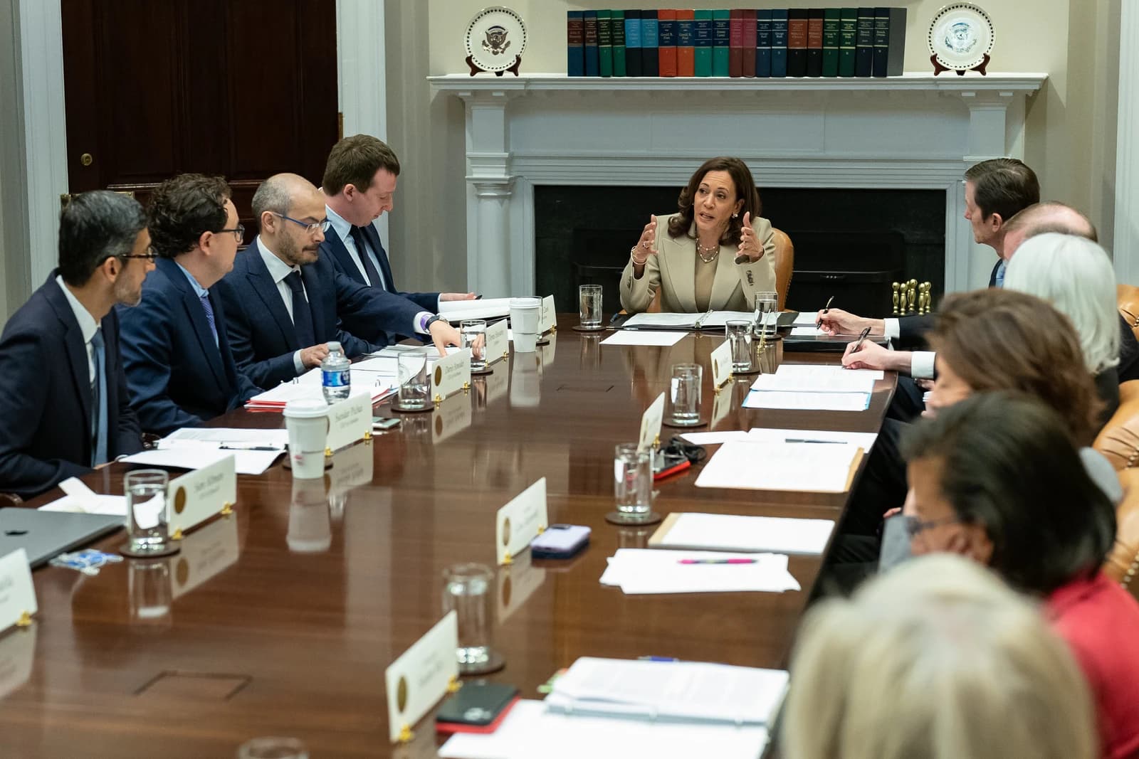 Vice President Kamala Harris speaking and gesturing during a meeting in a conference room.