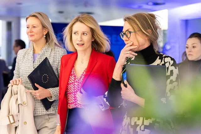 Kaja Kallas, Prime Minister of Estonia, walks with other officials at a conference.