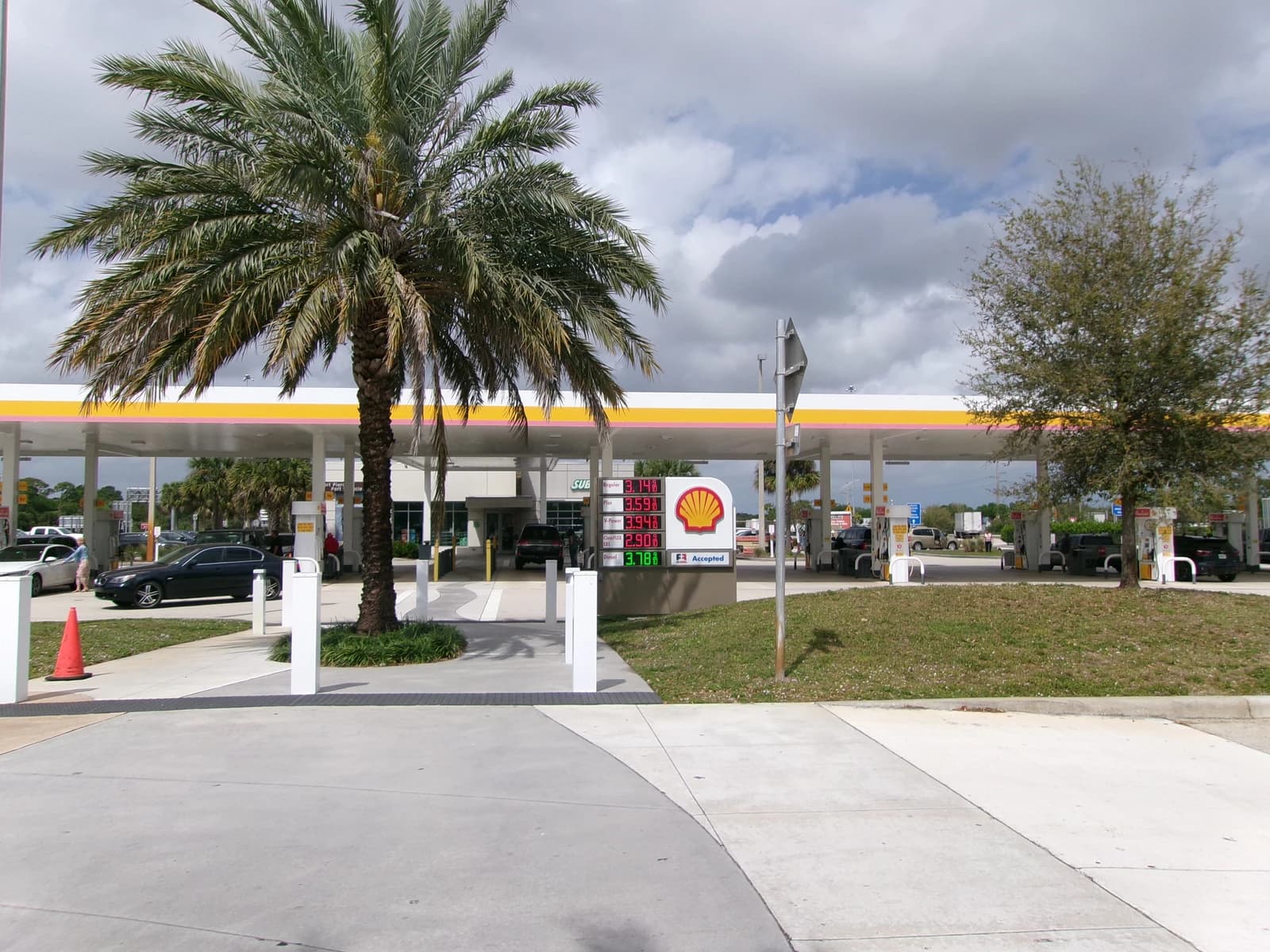 Shell gas station showing prices for various fuel types on a digital sign.