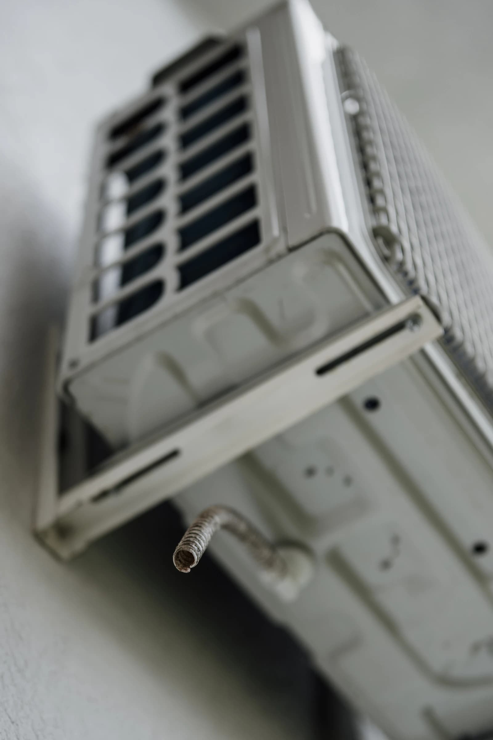 Air conditioning unit with a cooling pipe visible in a residential setting.