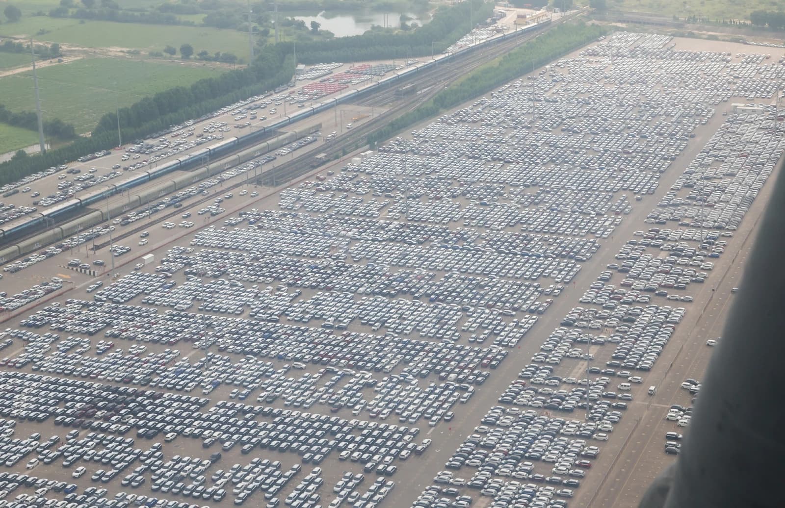 Aerial view of Maruti Suzuki facility in Hansalpur, Gujarat, with hundreds of cars parked.